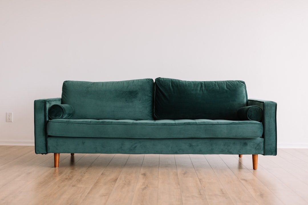 Home Cool hipster green couch sofa with brown wooden legs on wooden floor